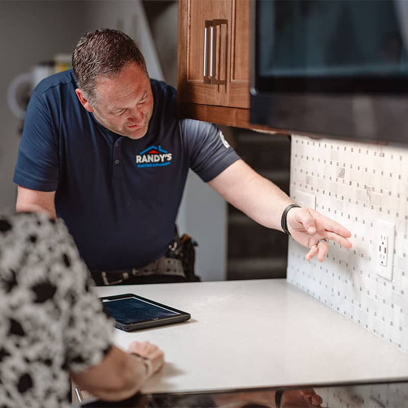 Randy demonstrating kitchen remodeling details to a customer beside a counter.