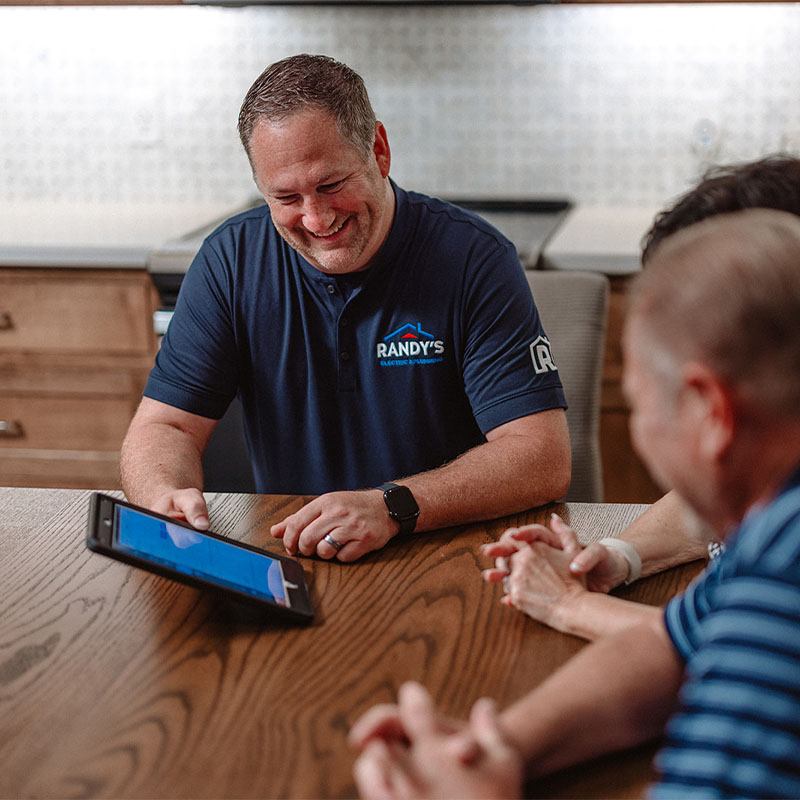 Randy showing tablet to clients in office meeting.