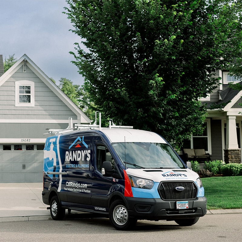 Randy's Electric & Plumbing van parked outside a suburban house.