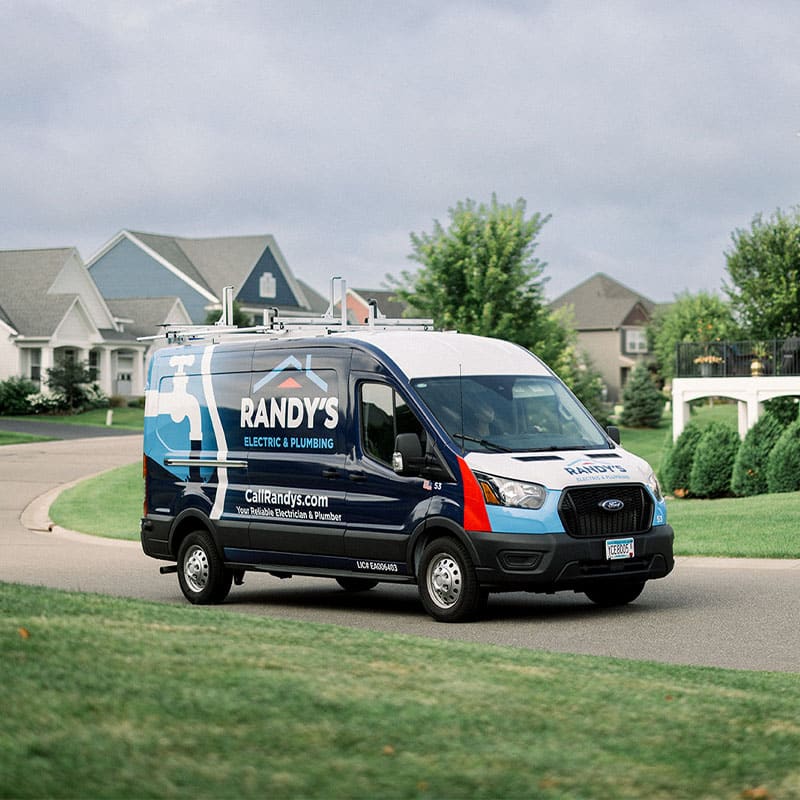 Randy’s Electric & Plumbing van driving through a suburban neighborhood.