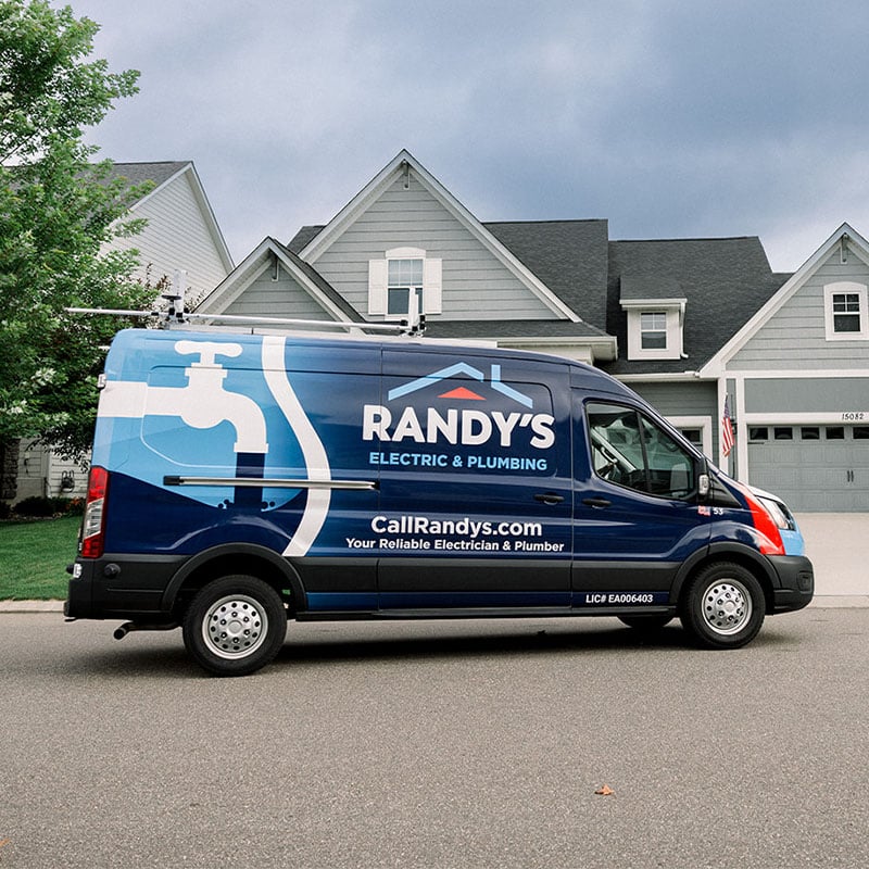 Randy's Electric & Plumbing van parked in front of a suburban house.