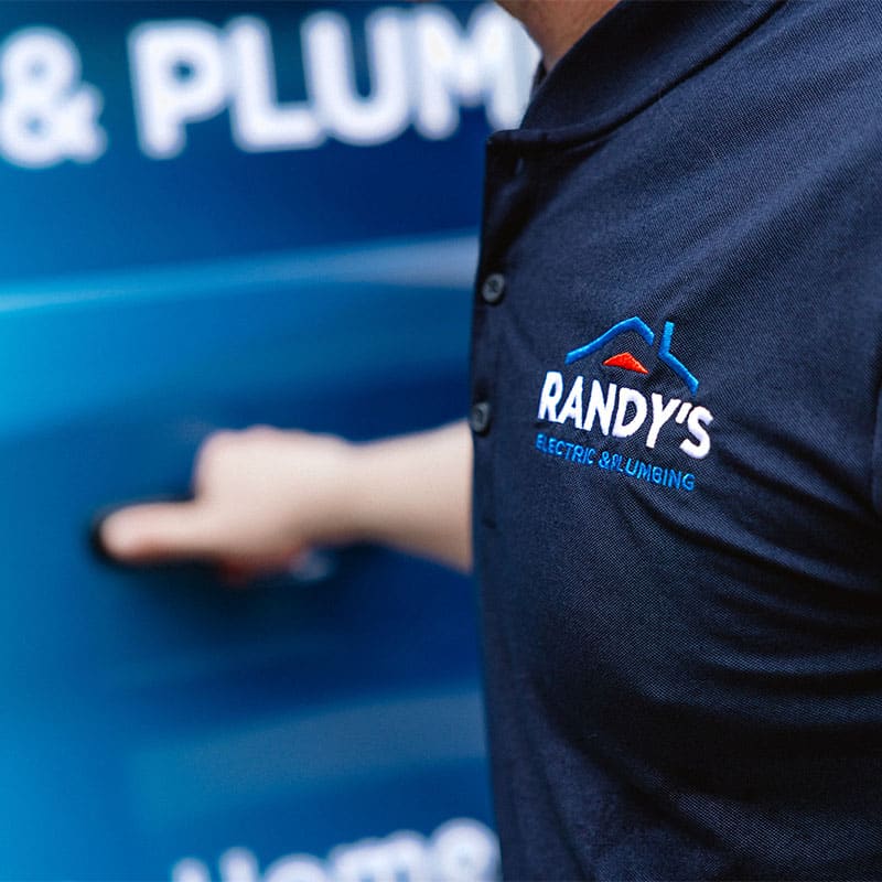 Randy's Electric & Plumbing employee opening blue service vehicle door.