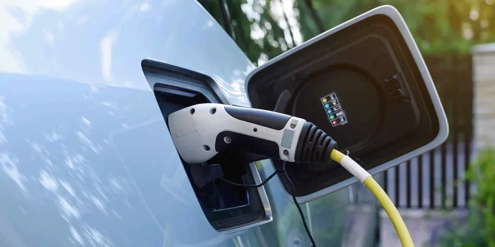 Electric car charging with plugged-in charger, close-up view.