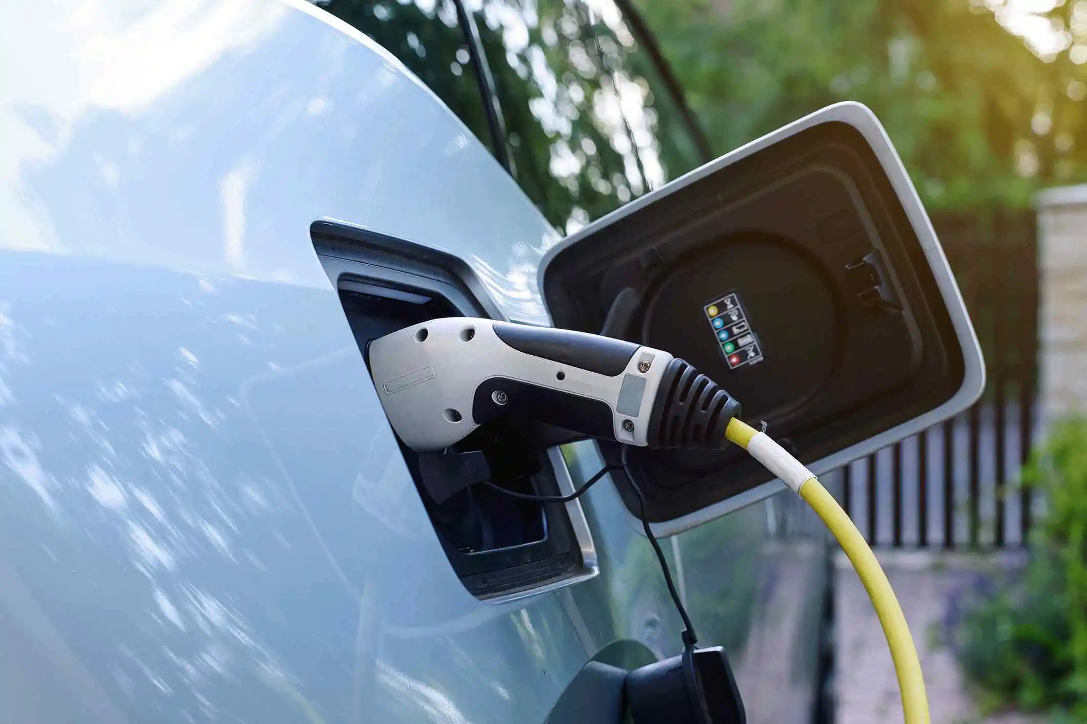 Electric car charging with plugged-in charger, close-up view.