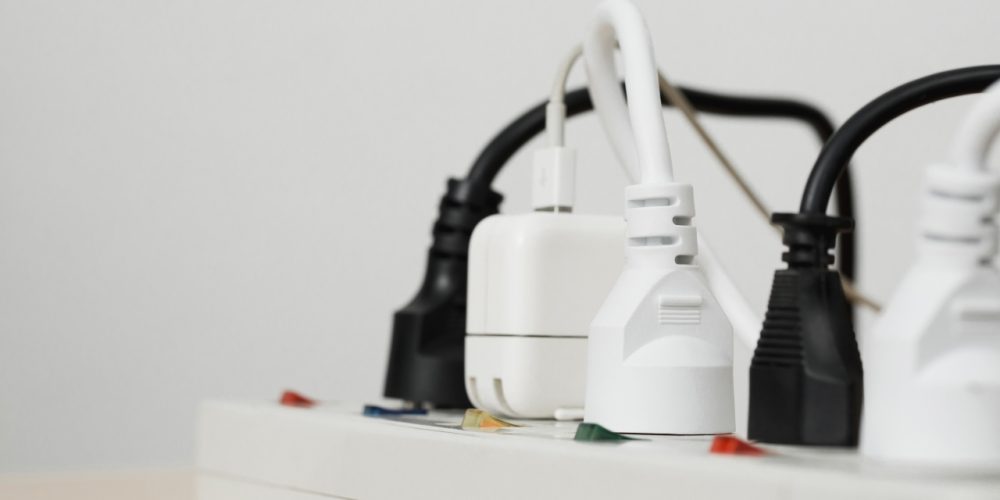 Power strip with white and black plugs connected, close-up view.