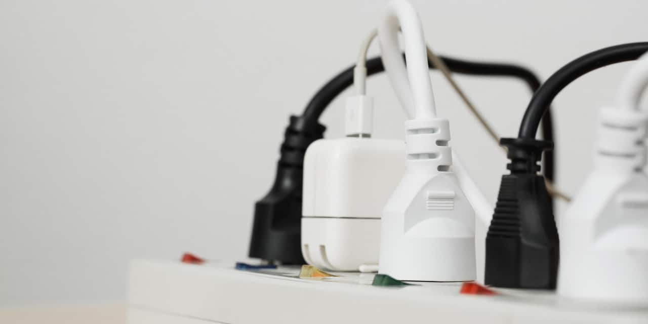 Power strip with white and black plugs connected, close-up view.
