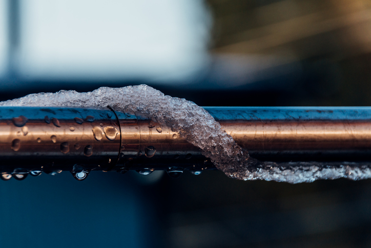 A frozen copper pipe covered with ice during a cold snap in Minnesota