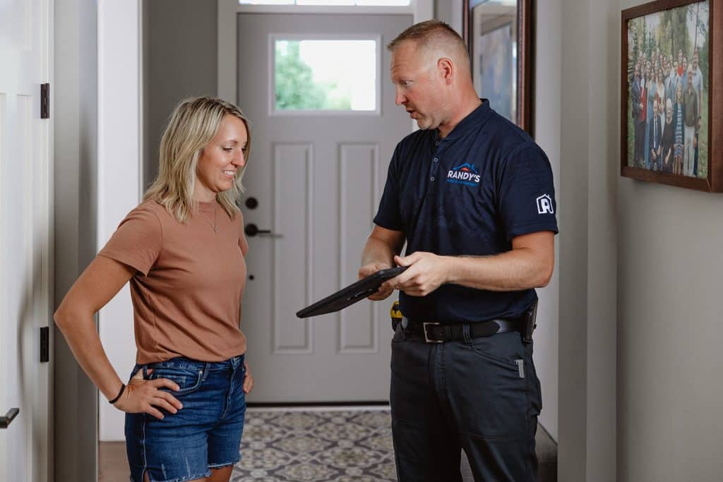 A plumber from Randy's Electrical & Plumbing going over a quote for sump pump repairs with a homeowner. 