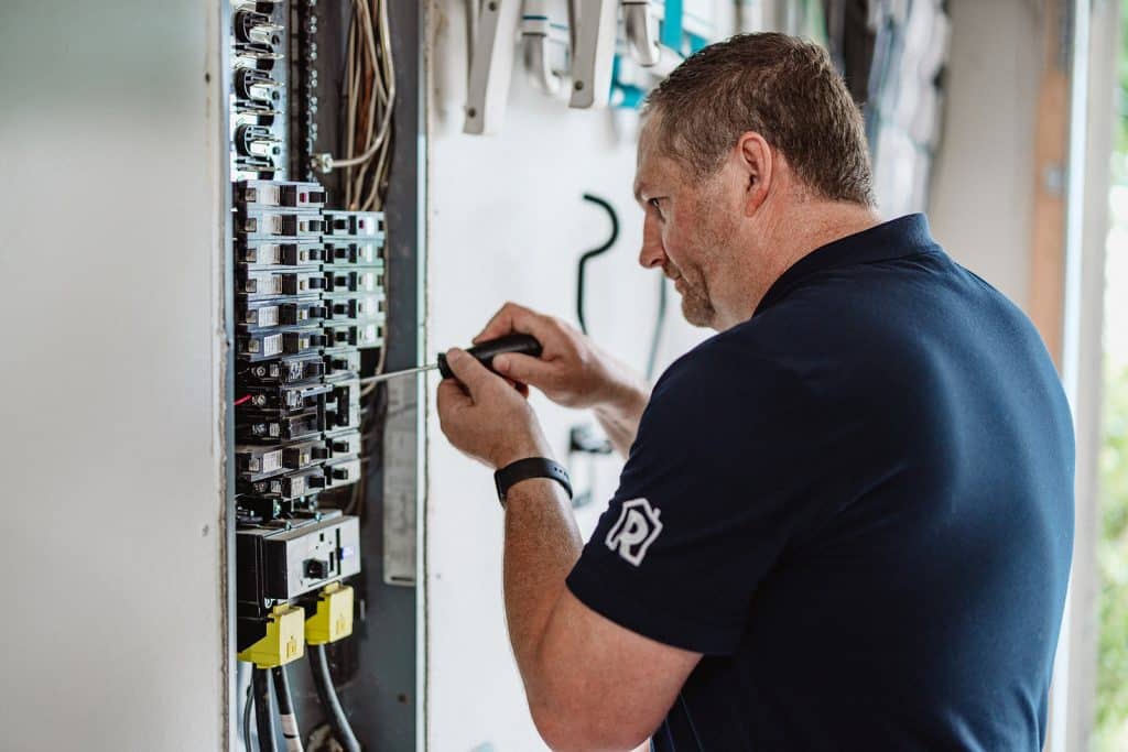 An electrician from Randy's Electric checking an electrical panel.