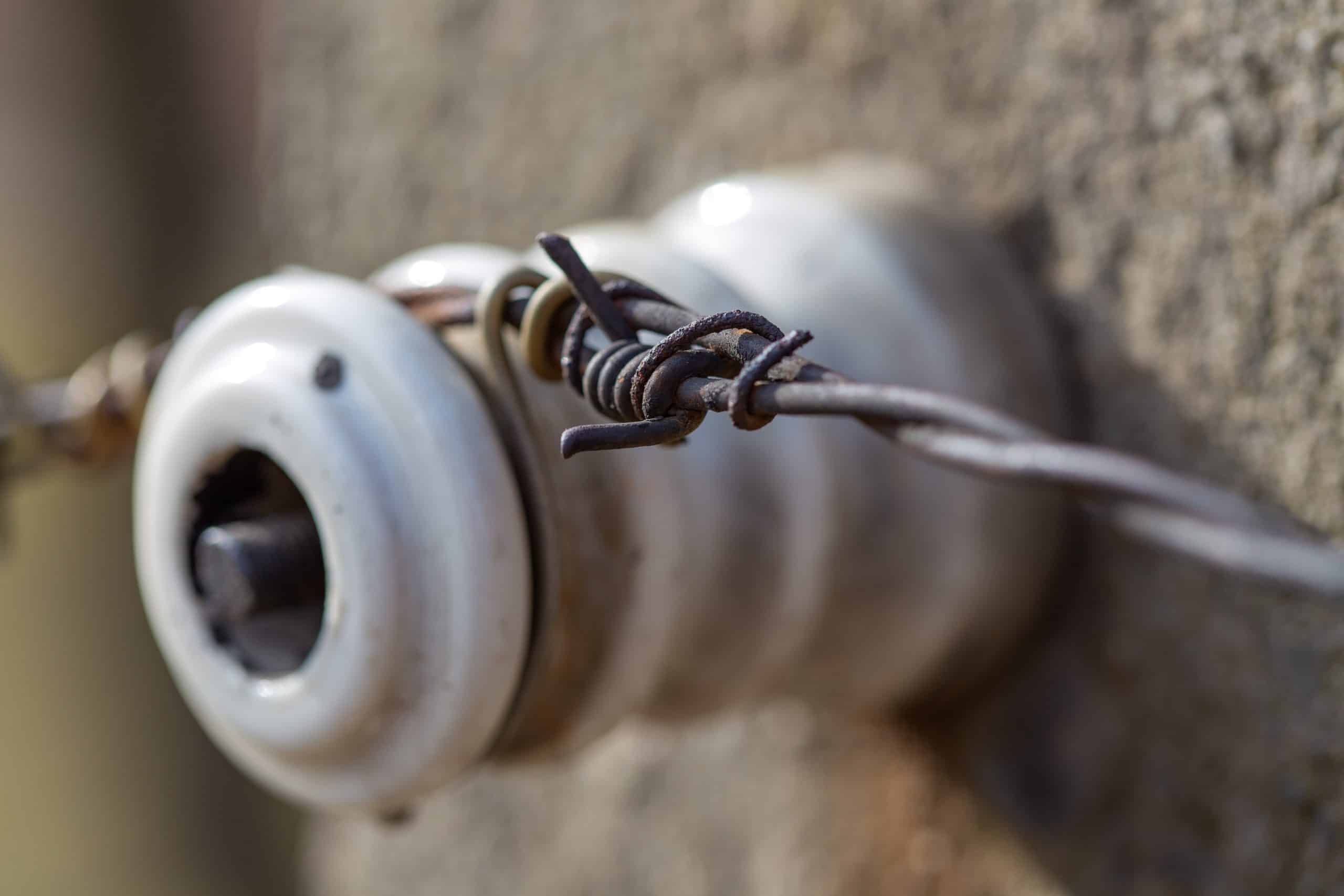 A closeup of old knob & tube wiring in a Minnesota home with a porcelain electrical insulator.