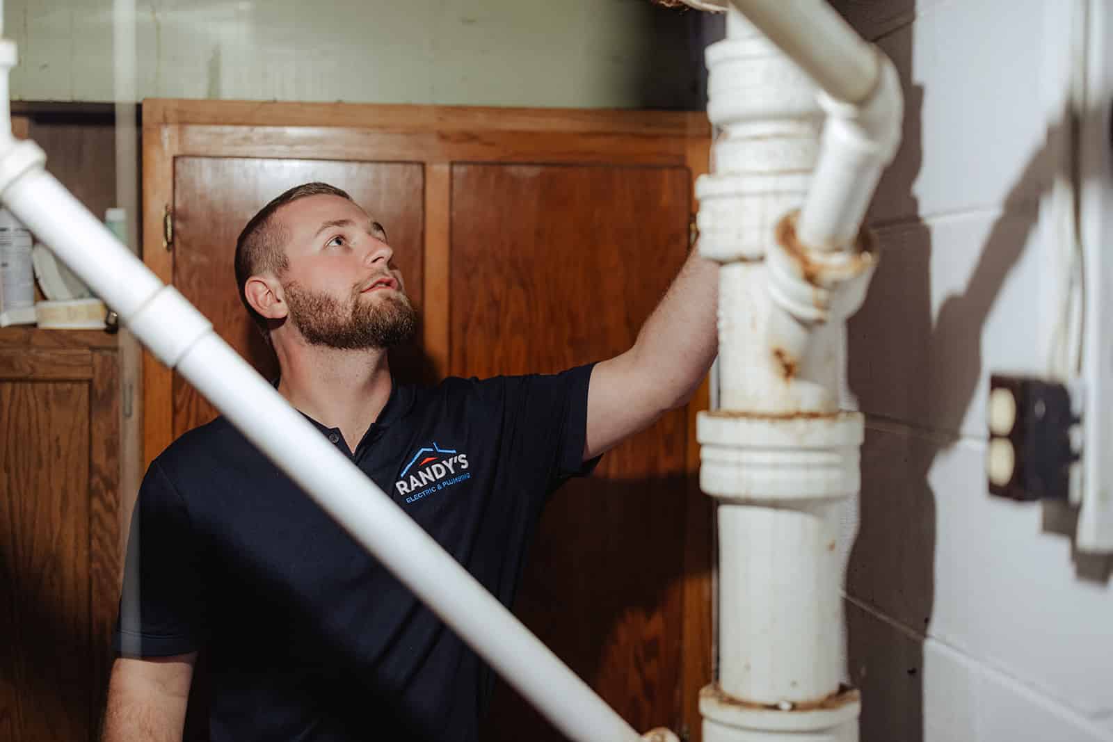 A licensed plumber from Randy&rsquo;s Electric & Plumbing checking the pipes after a sewage leak in a Twin Cities home.